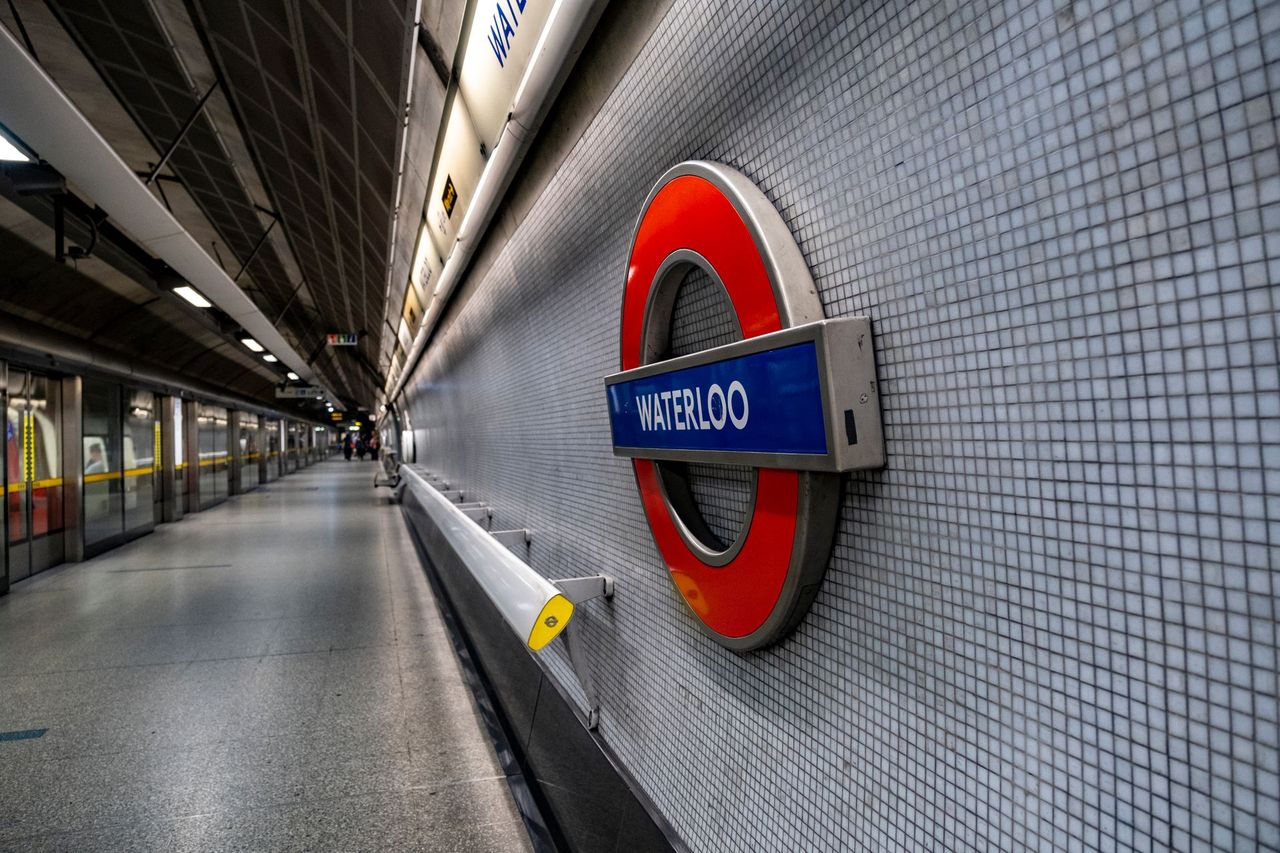 Waterloo roundel on a tiled platform wall, with the platform stretching away