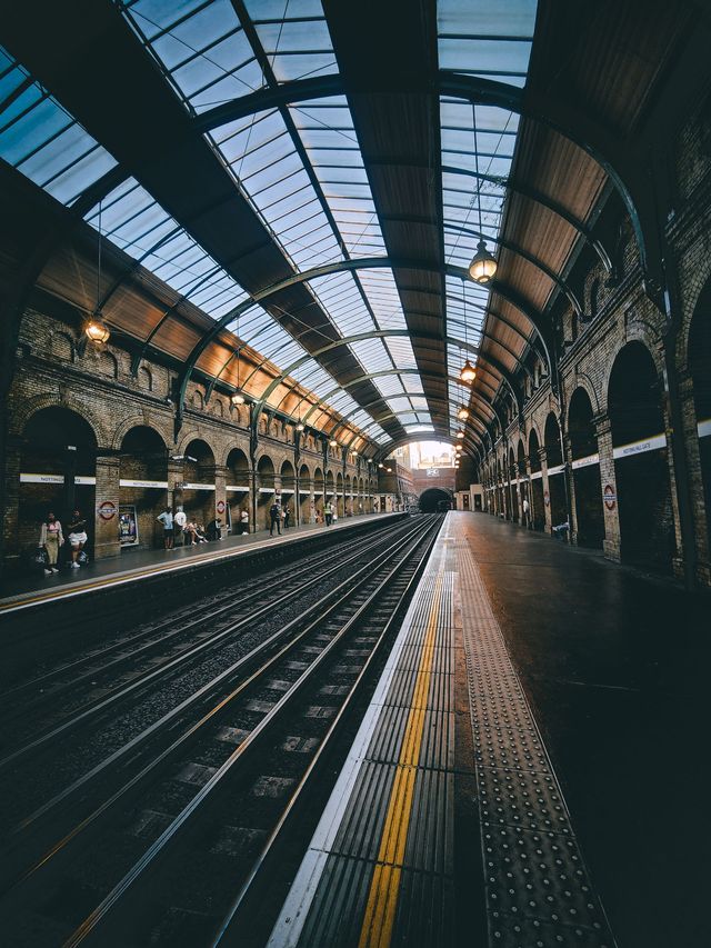 Platform at Notting Hill Gate under a glass roof on iron arches, with the track to the right